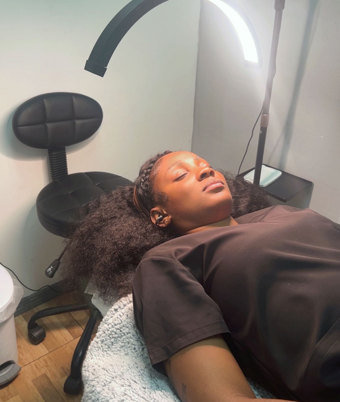 A client relaxing on the treatment bed under the ring light in the Ellimak studio
