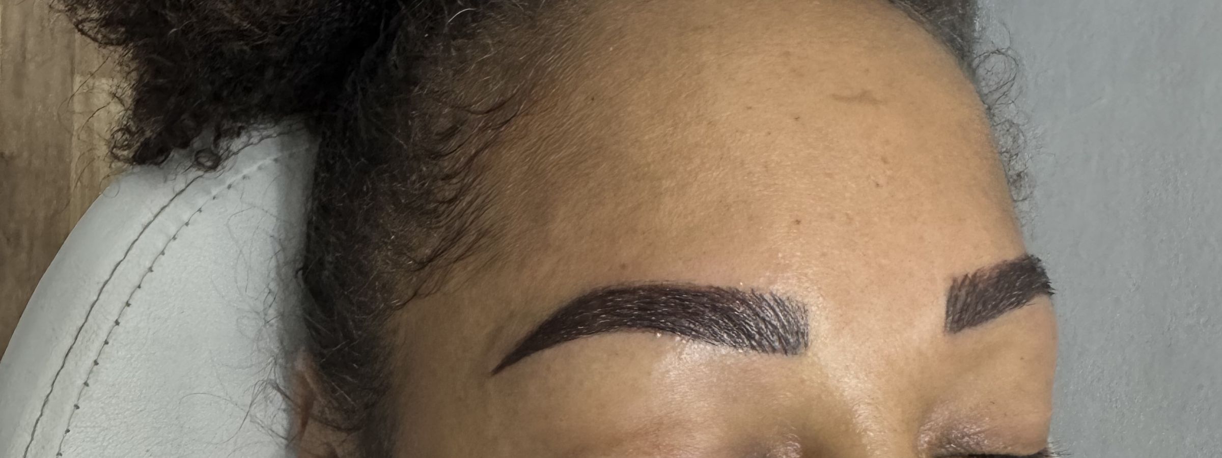 A client with microshaded brows resting in the treatment chair