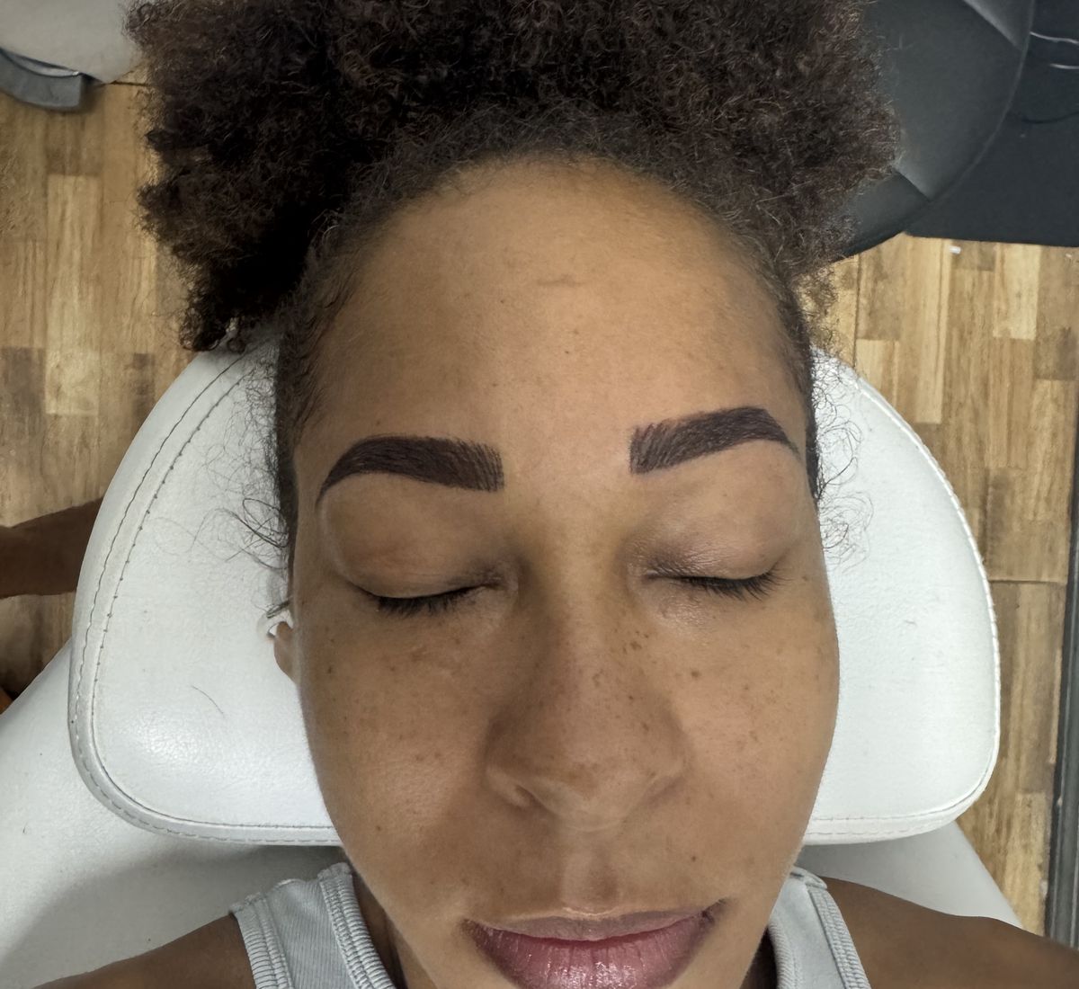A client with finished microshaded brows in the Ellimak treatment chair